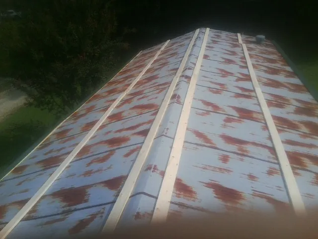 Rusted metal roof panels with new wood purlins before replacement — Storm Damage Roof Repair in Tallapoosa by Roofing Brothers