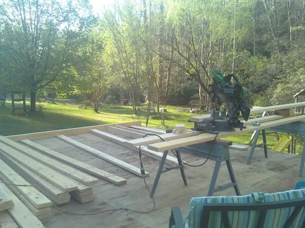 Miter saw and framing lumber on a deck under construction in Tallapoosa