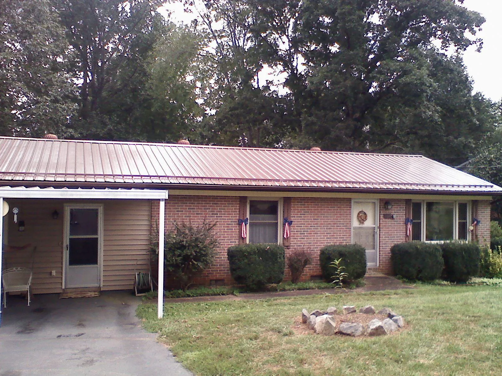 Bronze metal roof and carport on a brick ranch home — Roof Repair work by our crew in Tallapoosa